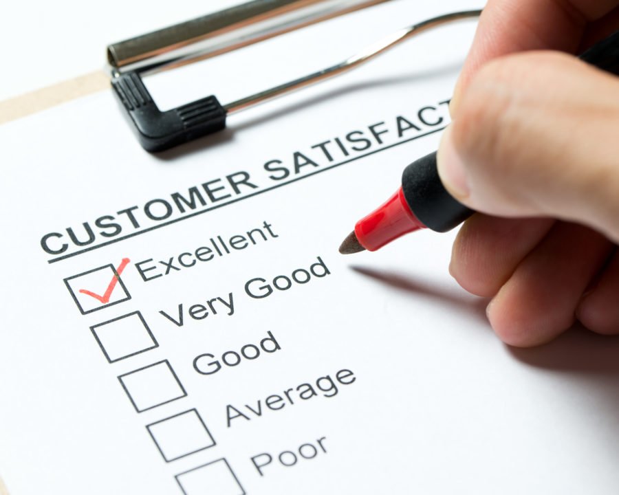 Customer satisfaction survey form on clipboard with red pen