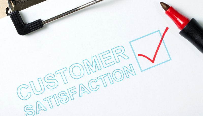 Customer satisfaction survey form on clipboard with red pen